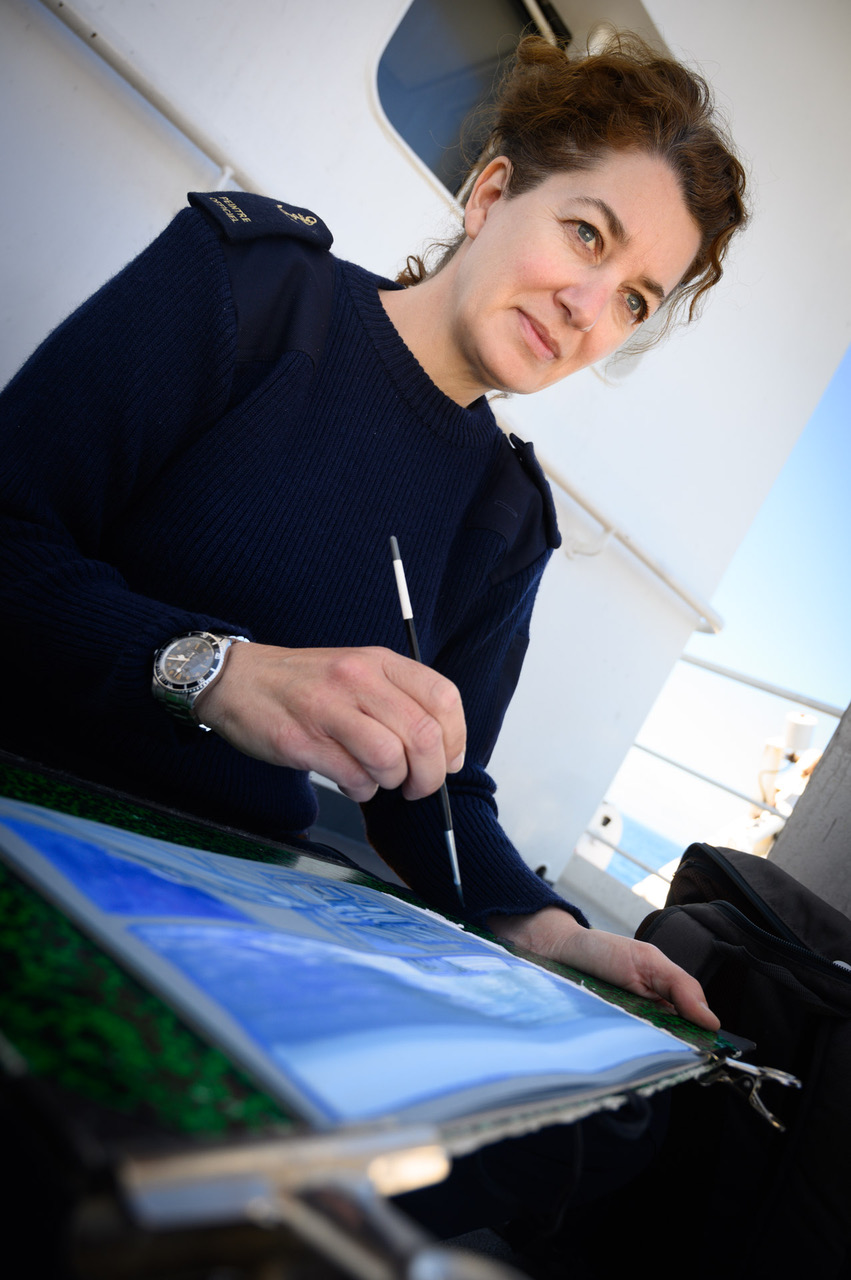 Marie Détrée, peintre officiel de la Marine nationale, peint le chargement du patrouilleur polaire l'Astrolabe lors de la rotation R2-OUT. À bord, le 21 janvier 2022. © Marine nationale