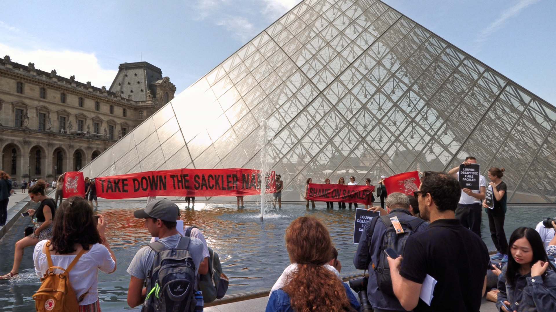 Nan Goldin et les membres du collectif P.A.I.N manifestant à l'été 2019 devant la pyramide du Louvre pour réclamer que l'aile Sackler soit débaptisée. © Avec l’aimable autorisation de Nan Goldin