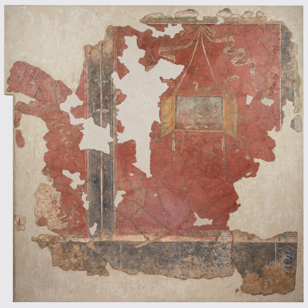 Enduit peint aux xenia (cadeaux d’hospitalité). Le tableau à volets est suspendu par un ruban sur un fond rouge, surmonté d’un cygne et rempli de diverses victuailles (volailles, fruits, lapins, etc.), cadeaux de bienvenue de l’hôte à l’étranger qu’il reçoit. Peinture murale du 4e style pompéien. 50-70 de notre ère. Lugdunum – Musée & Théâtres romains.