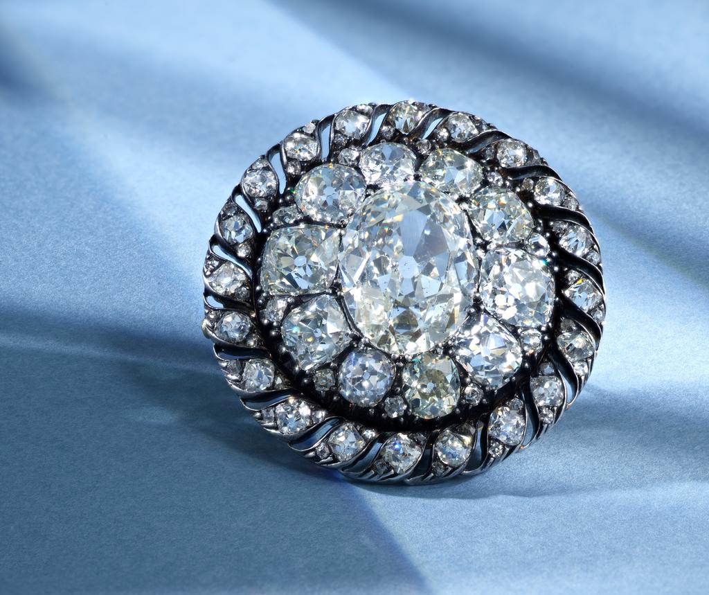 Bijou de chapeau de Napoléon Ier, début du XIXe siècle. Solitaire de 13,04 carats, entouré de diamants de taille ancienne et de taille Mazarin sertis dans une bordure ajourée. Vente Genève, Sotheby’s, 12 novembre 2025. Estimé 120 000/200 000 CHF.